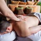 a male laying on a massage table outside by the pool