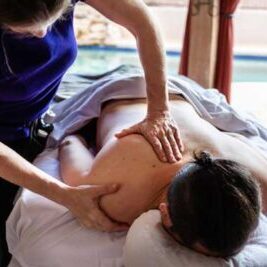 Male laying getting a poolside massage in Cave Creek AZ, with licensed massage therapist providing the massage